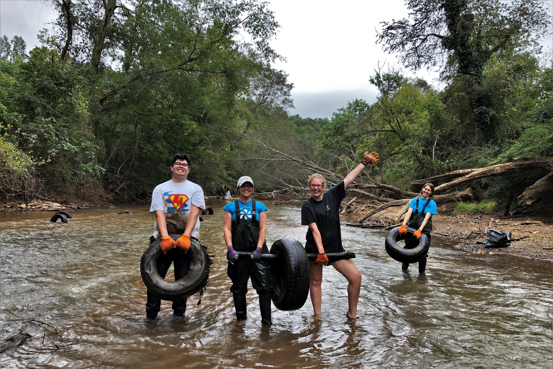 Volunteers in stream with tires